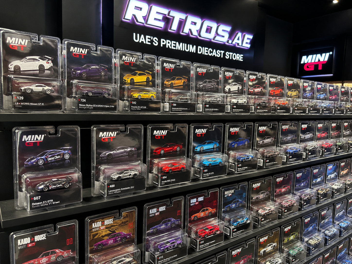 MINI GT 1:64 diecast cars displayed on shelves at Retros.ae in the UAE featuring premium collectible model cars.